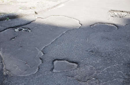 Broken asphalt and cracks on the road surfaceの写真素材