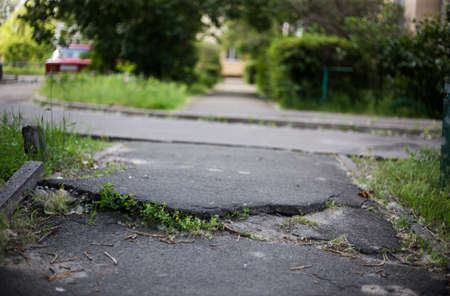 Broken asphalt and cracks on the road surface