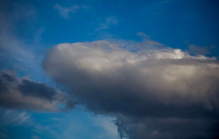 Fluffy clouds cover the summer blue sky
