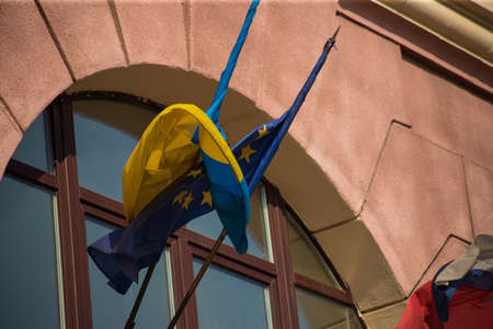 European union flag and ukrainian flag fluttering against building facade