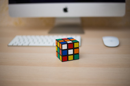 Colored 3D combination puzzle Rubik's cube three by three lies on a wooden tableのeditorial素材