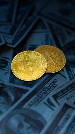 Gold bitcoin coin on the background of dollar bills