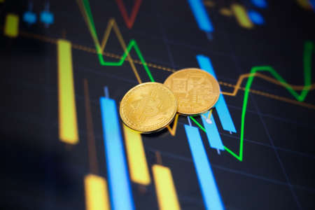 Gold bitcoin coin against the background of the cryptocurrency rate index chart