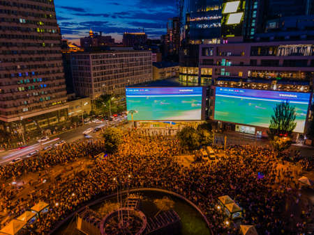 Kyiv, Ukraine 06/30/2020: A large group of fans in the square near large screens with the broadcast of the football match for Euro 2020 between Ukraine and Sweden near Guliver mallのeditorial素材