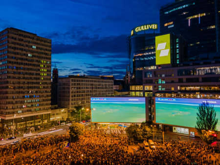 Kyiv, Ukraine 06/30/2020: A large group of fans in the square near large screens with the broadcast of the football match for Euro 2020 between Ukraine and Sweden near Guliver mallのeditorial素材