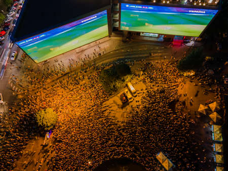 Kyiv, Ukraine 06/30/2020: A large group of fans in the square near large screens with the broadcast of the football match for Euro 2020 between Ukraine and Sweden near Guliver mallのeditorial素材
