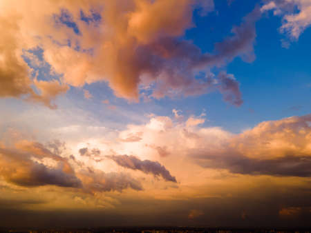 Aerial view on rain clouds at sunset over the city