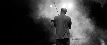 View from the back of a man playing the violin on stageの写真素材