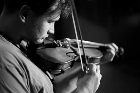 A man plays the violin on the stage of closeの写真素材