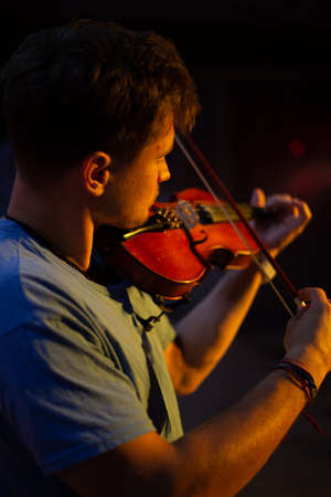 A man plays the violin on the stage of closeの写真素材