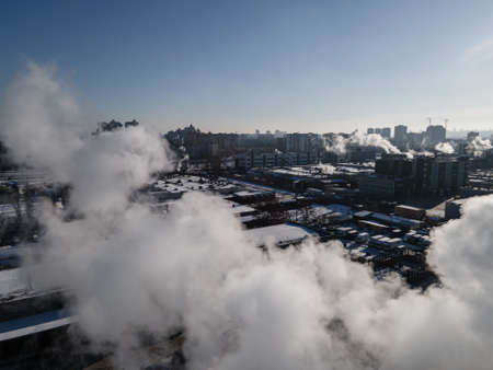 Aerial view from a drone to the factory and to air pollution in the cityの写真素材