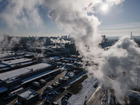 Aerial view from a drone to the factory and to air pollution in the cityの写真素材