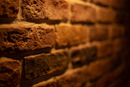 Brick wall illuminated by warm light from a lampの写真素材