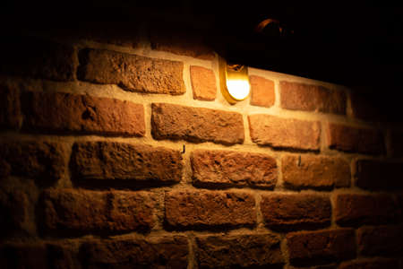 Brick wall illuminated by warm light from a lampの写真素材