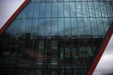 Modern architecture, straight and oblique lines, red color of the facade and a lot of glazing