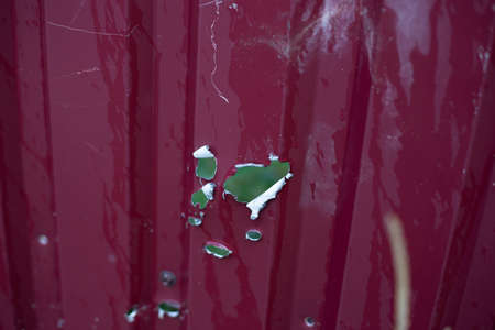 Fence near the house with bullet holes and charapnels after gunshots and fighting during the invasion of Russian troops into Ukraineの写真素材