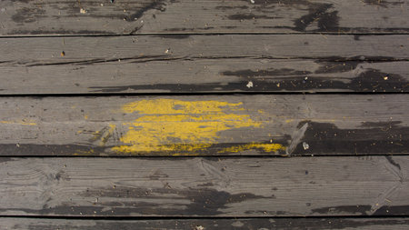 Old board with the remains of yellow paint in detailの写真素材
