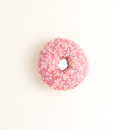 White donuts with black crumb on a pink background isolatedの写真素材