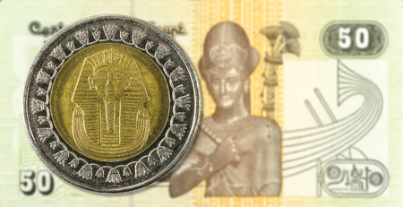 1 egyptian pound coin agianst 50 egyptian pound bank note reverse