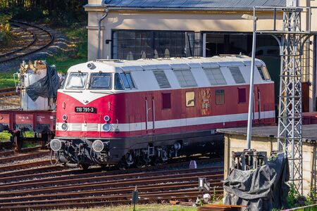 Loebau, Saxony, Germany - 10.12.2019; red historic diesel locomotive waiting in locomotive shed for maintenanceのeditorial素材