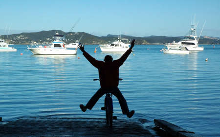 Boy cycling with his bike into the sea.の写真素材
