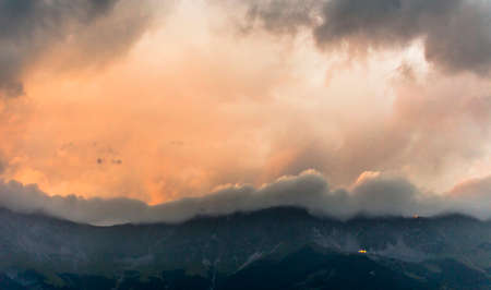 Sunset behind the clouds at the mountains at the Austrian Alps