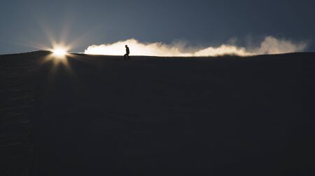 Skiers enjoying an early morning in slopes at the Austrian Alps with a nice sunshine backlightの写真素材