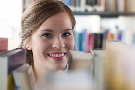 Portrait of female student selecting a bookの写真素材