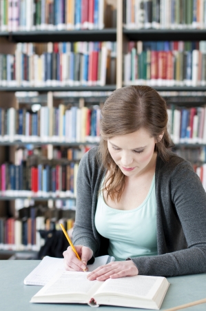 Portrait of female student studying at the tableの写真素材