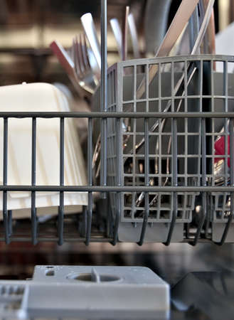 Close up of open dishwasher with full clean load of kitchenware.の写真素材