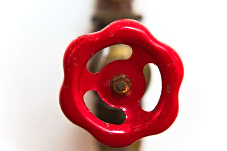 Old red valve on water pipes isolated on white.