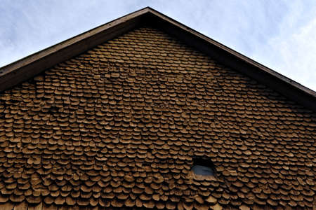 Old worn wood roof shingles or tiles in brown and yellow colors.の写真素材