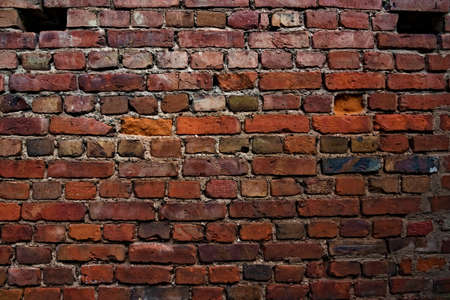 Old weathered red brick wall with damaged to it. . High quality photoの写真素材