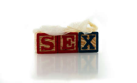 Wooden alphabet blocks spelling sex with a used condom on top. Isolated on white background. . High quality photoの写真素材