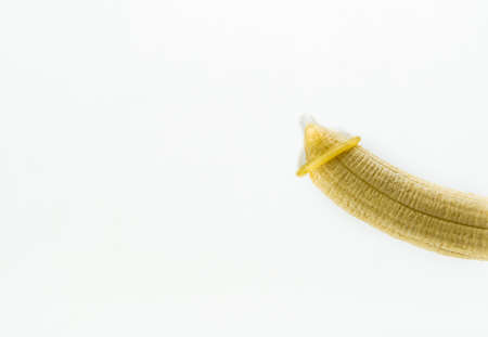 Condom on the tip of a banana, symbolizing a penis. Concept of safe sex and protection. Isolated on white background. . High quality photoの写真素材