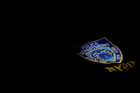 badge of the New York police department on a cloth shirt isolated on black. High quality photoの写真素材