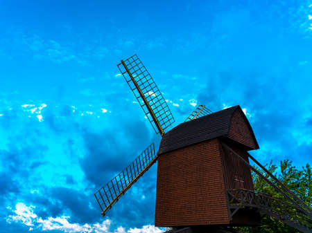 Traditional medieval wind mill made from wood and build to make flour from grains. With blue skies...
