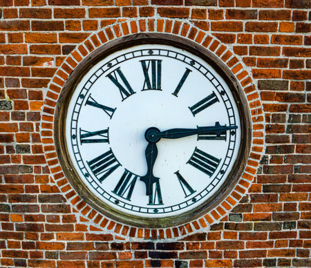 Old clock in a church tower with bricks around it. Close up. . High quality photo