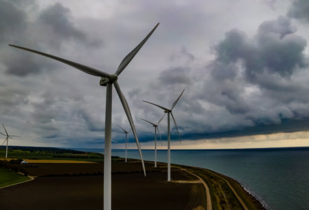 Wind turbines by the sea, generating clean energy on a stormy day. . High quality photoの写真素材