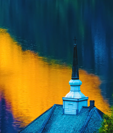 Church spire with a cross and yellow shades of sunlight reflecting in the water. . High quality photoの写真素材