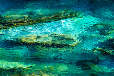 Crystal clear glacial melting water running over smooth rocks and pebbles in a wild forest river. Close up. . High quality photoの写真素材