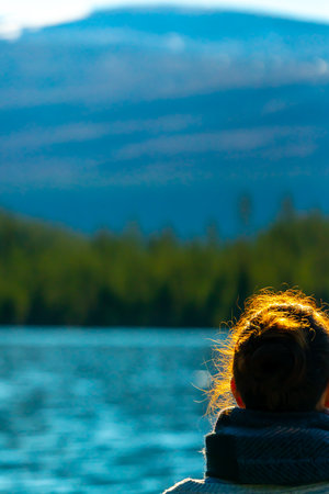 Woman standing by a mountain lake. Blurred background. . High quality photoの写真素材