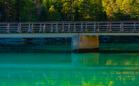 Bridge over a serene emerald green river in the mountains. High quality photoの写真素材