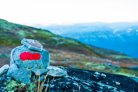 A rock with a bright red marking indicating a path through the mountains. Placed by the Norwegian tourist association DNT. . High quality photoの写真素材