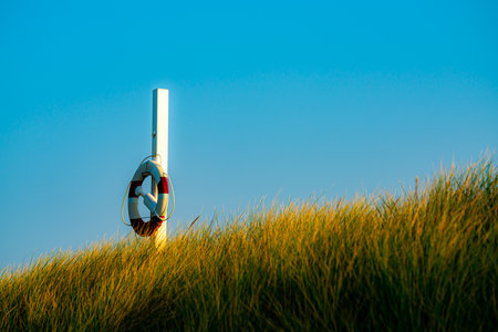 Round life saving buoy hanging ready on a pole by the beach. . High quality photoの写真素材