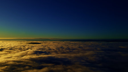 Flying above the clouds into the sunset or sunrise with deep blue and black skies above. High quality photoの写真素材