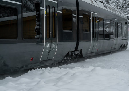 Passenger train from Oslo passing by a station on a cold, snowy winters day. High quality photoの写真素材