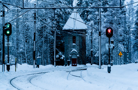 Railroad junction with signal lights and powerlines in deep snow in the winter.の写真素材