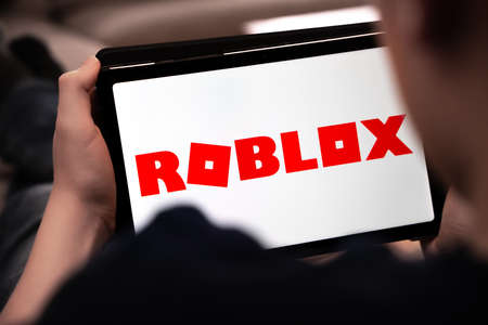 Child playing Roblox on a tablet. Shallow depth of field. High quality photoのeditorial素材