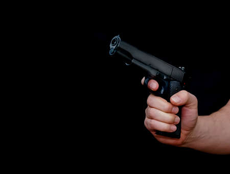 Hand holding a gun, isolated on black background. High quality photoの写真素材